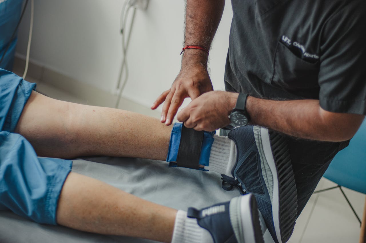 Physiotherapist Standing over Patient Lying Down